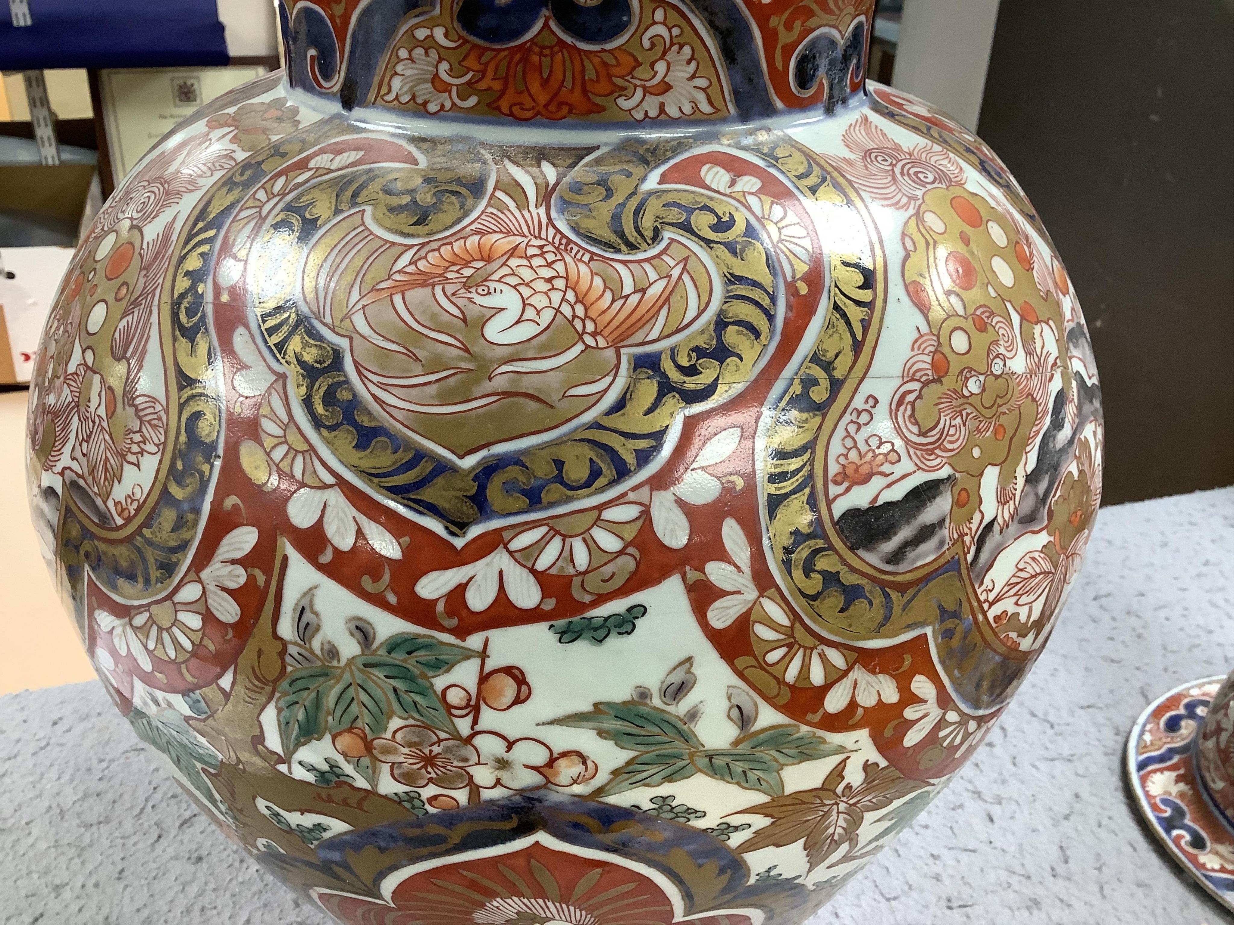 A large 19th century Imari vase with dragon finial to cover, 61cm high. Condition - badly cracked and restored